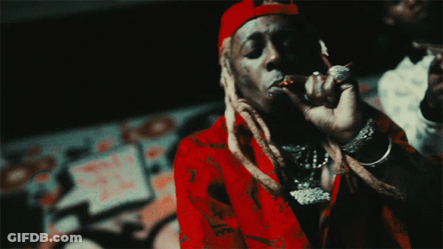 A Man Wearing A Red Shirt And A Red Hat Is Smoking A Cigarette GIF