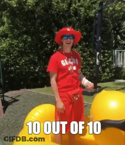 A Man Wearing A Red Shirt And A Red Hat Is Standing On A Yellow Float . GIF