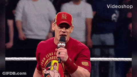 A Man Wearing A Red Shirt That Says John Cena On It Is Holding A Microphone GIF