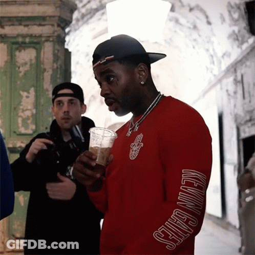A Man Wearing A Red Shirt That Says Kevin Gates On The Sleeve GIF
