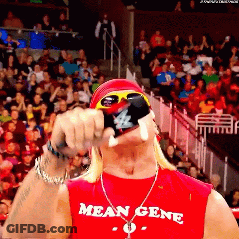 A Man Wearing A Red Shirt That Says Mean Gene Holds A Bottle In His Hand GIF