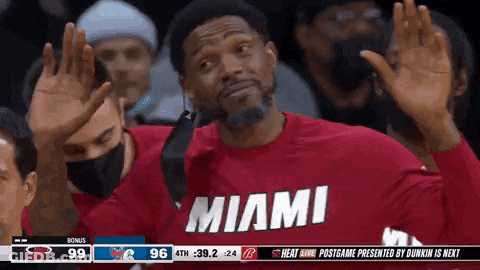 A Man Wearing A Red Shirt That Says Miami Is Waving His Hands In The Air . GIF