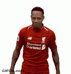 A Man Wearing A Red Shirt That Says Standard Chartered On It Is Laughing . GIF