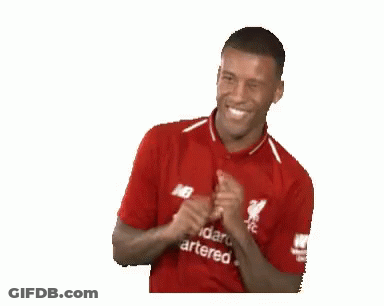 A Man Wearing A Red Shirt That Says Standard Chartered On It Is Smiling . GIF