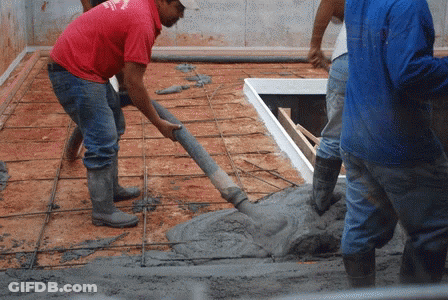 A Man Wearing A Red Shirt That Says ' Texas ' On It Pours Concrete GIF
