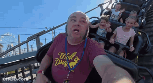 A Man Wearing A Red Shirt That Says Wall Drug Is Riding A Roller Coaster GIF