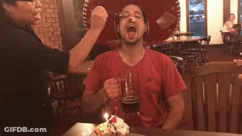 A Man Wearing A Red Shirt With A Dc Logo On The Front GIF