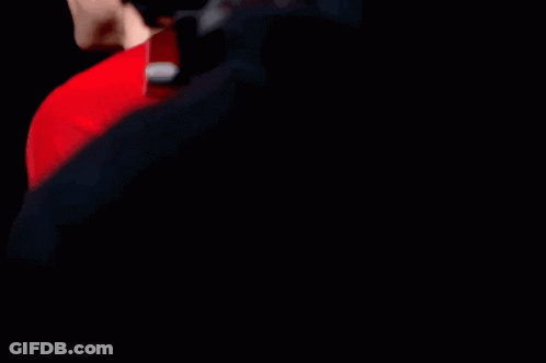 A Man Wearing A Red Shirt With Expedia Written On The Sleeve GIF