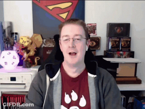 Man In Red Shirt With Paw Prints In Front Of Superman Painting GIF