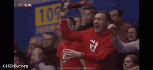 A Man Wearing A Red Shirt With The Letter K On It Is Screaming In A Crowd GIF