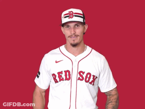 A Man Wearing A Red Sox Jersey Is Waving His Hands In The Air GIF