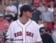 A Man Wearing A Red Sox Jersey Stands In Front Of A Crowd Of People GIF
