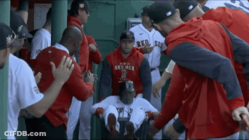 A Man Wearing A Red Sox Sweatshirt Is Surrounded By Other Baseball Players GIF