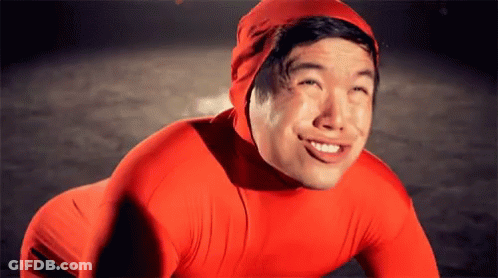 A Man Wearing A Red Suit And A Red Hat Smiles For The Camera GIF