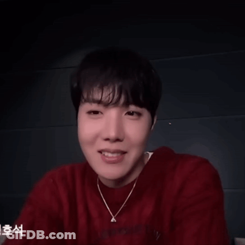 A Man Wearing A Red Sweater And A Necklace With The Letter A On It GIF