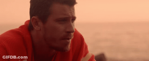 A Man Wearing A Red Sweater Looks At The Ocean GIF