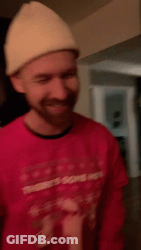A Man Wearing A Red Sweater That Says There 'S Some Hos On It GIF