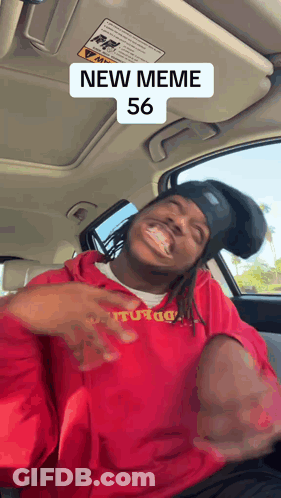 A Man Wearing A Red Sweatshirt With The Number 56 On It Is Sitting In A Car GIF