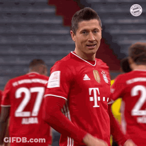 A Man Wearing A Red T-Mobile Jersey Is Standing In Front Of A Group Of Soccer Players . GIF
