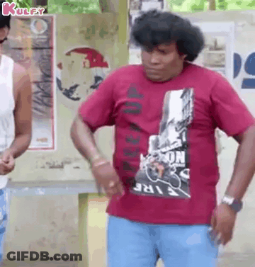 A Man Wearing A Red T-Shirt And Blue Jeans Is Standing In Front Of A Wall . GIF