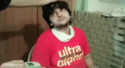 A Man Wearing A Red T-Shirt With The Word Ultra On It Is Sitting In A Chair . GIF