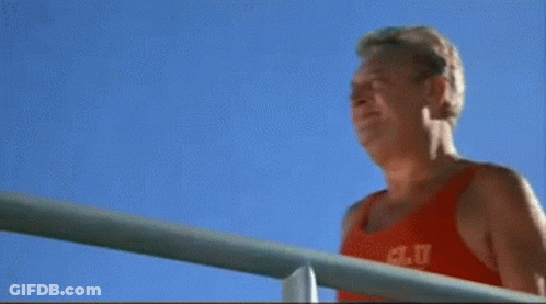 A Man Wearing A Red Tank Top That Says A.c.u.t. On It GIF