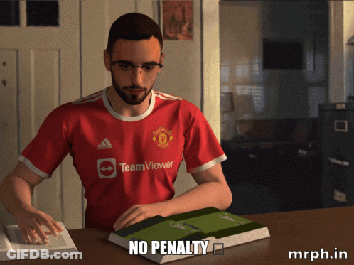 A Man Wearing A Red Teamviewer Jersey Sits At A Table GIF
