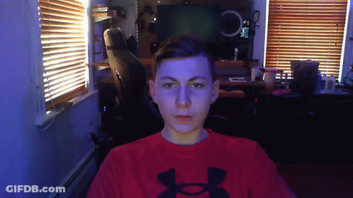 A Man Wearing A Red Under Armour Shirt Is Looking At The Camera GIF