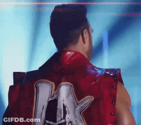 A Man Wearing A Red Vest With The Letter A On The Back GIF