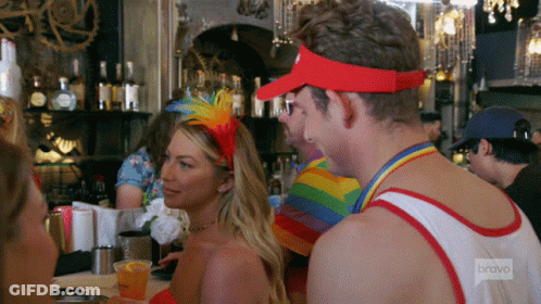 A Man Wearing A Red Visor Is Talking To A Woman In A Red Dress GIF