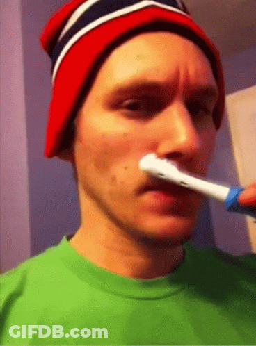 A Man Wearing A Red White And Blue Hat Brushing His Teeth GIF