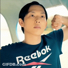 A Man Wearing A Reebok T-Shirt Is Flexing His Muscles GIF