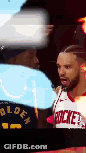 A Man Wearing A Rockets Jersey Stands Next To Another Man GIF