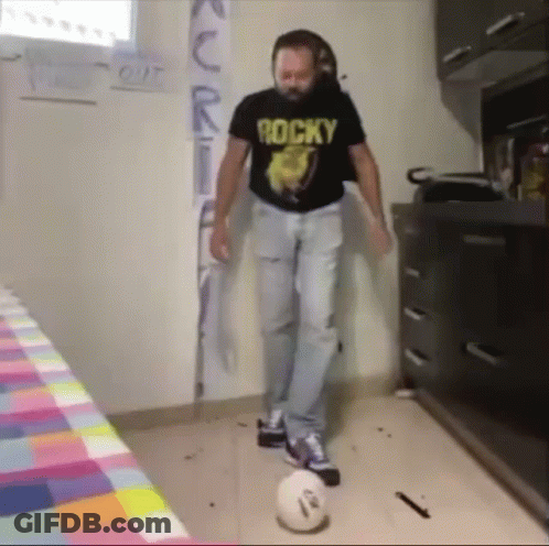 A Man Wearing A Rocky Shirt Is Kicking A Ball GIF