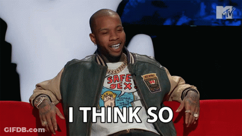 A Man Wearing A Safe Sex T-Shirt Sits On A Red Couch GIF