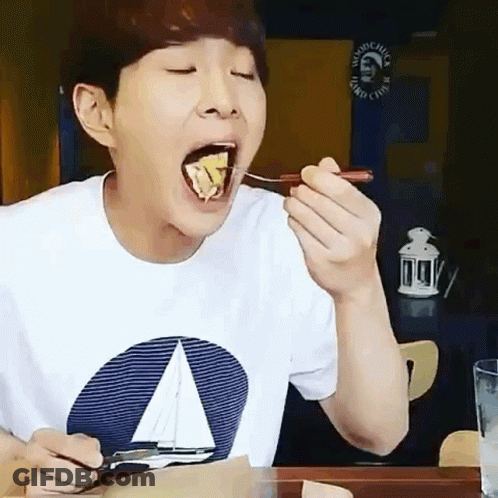 A Man Wearing A Sailboat Shirt Is Eating Food With A Spoon GIF