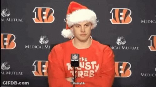 A Man Wearing A Santa Hat And A Red Sweater That Says " The Lusty Krab " GIF