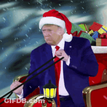 A Man Wearing A Santa Hat Is Riding In A Sleigh GIF