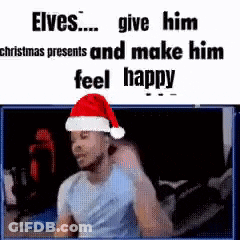 A Man Wearing A Santa Hat Is Sitting In Front Of A Screen . GIF