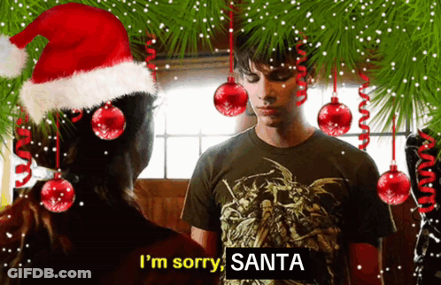 A Man Wearing A Santa Hat Says I 'M Sorry Santa In Front Of A Woman GIF