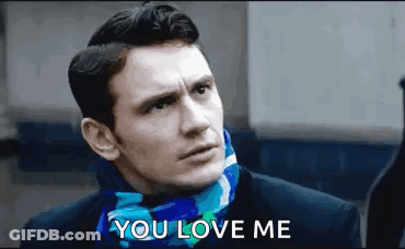 A Man Wearing A Scarf Around His Neck Is Talking To Someone . GIF