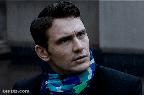 A Man Wearing A Scarf Around His Neck Looks To The Side GIF