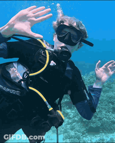 A Man Wearing A Scubapro Scuba Diving Suit Is Swimming In The Ocean GIF