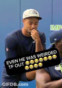 A Man Wearing A Seahawks Hat Is Holding Another Man 'S Hand GIF