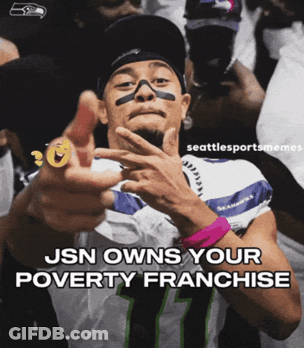 A Man Wearing A Seahawks Jersey Is Pointing At The Camera GIF