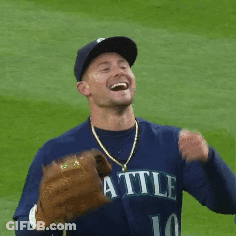 A Man Wearing A Seahawks Jersey Is Smiling And Holding A Glove GIF