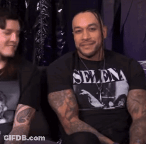 A Man Wearing A Selena T-Shirt Is Smiling GIF