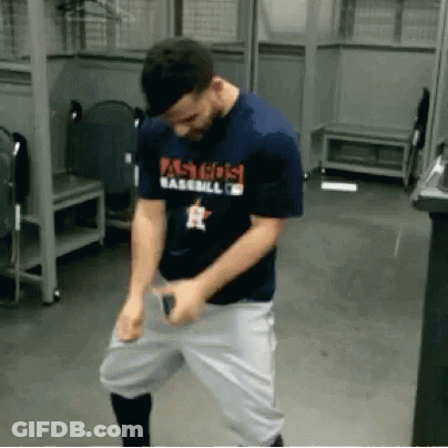 A Man Wearing A Shirt That Says Astros Baseball Is Dancing In A Locker Room GIF