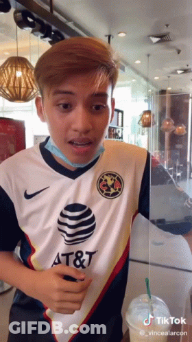 A Man Wearing A Shirt That Says At & T Is Standing In A Restaurant GIF