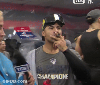 A Man Wearing A Shirt That Says " Champions " Smoking A Cigar GIF